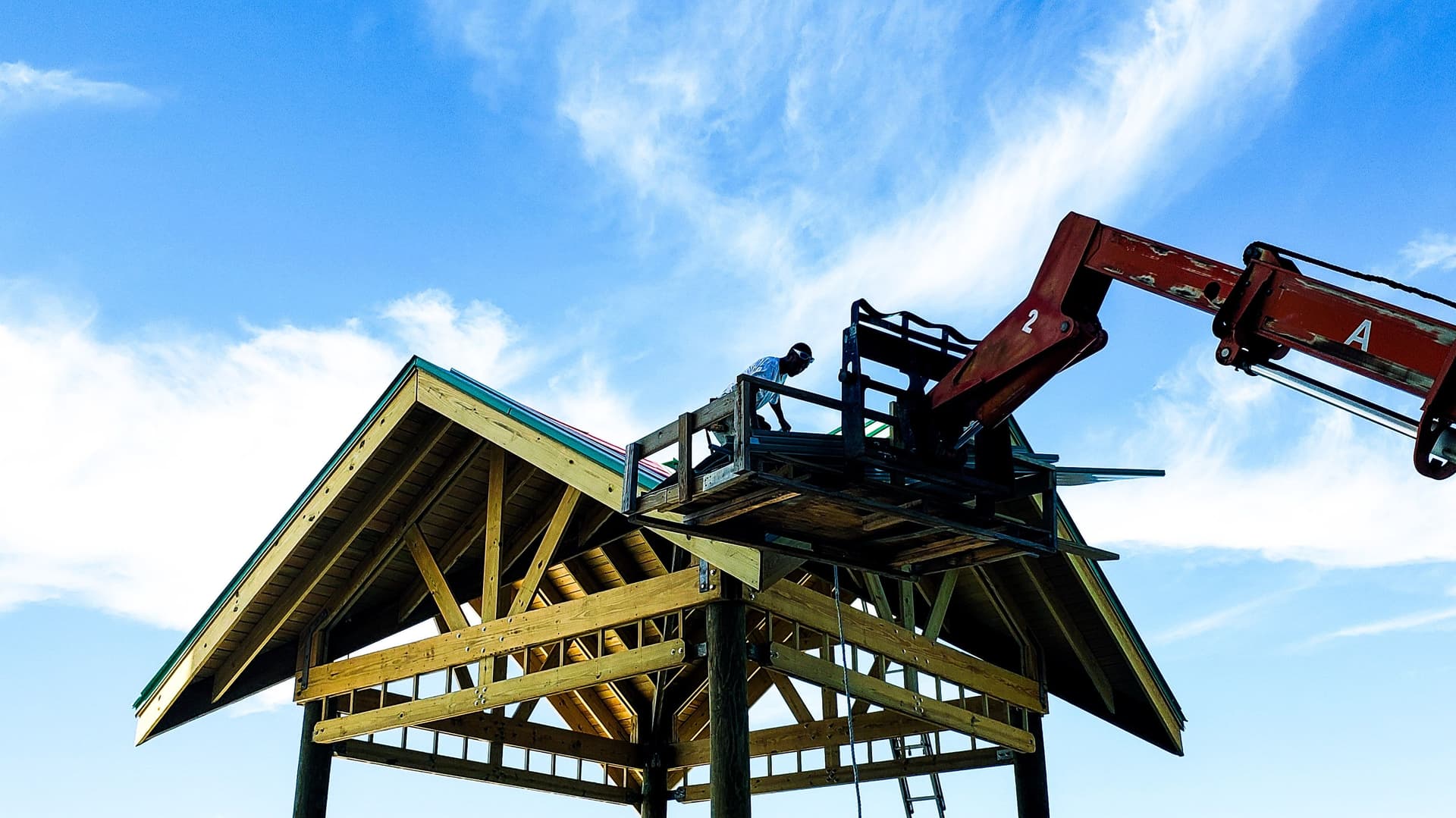 mechanical-crane-lifts-shingles-up-on-rooftop-for